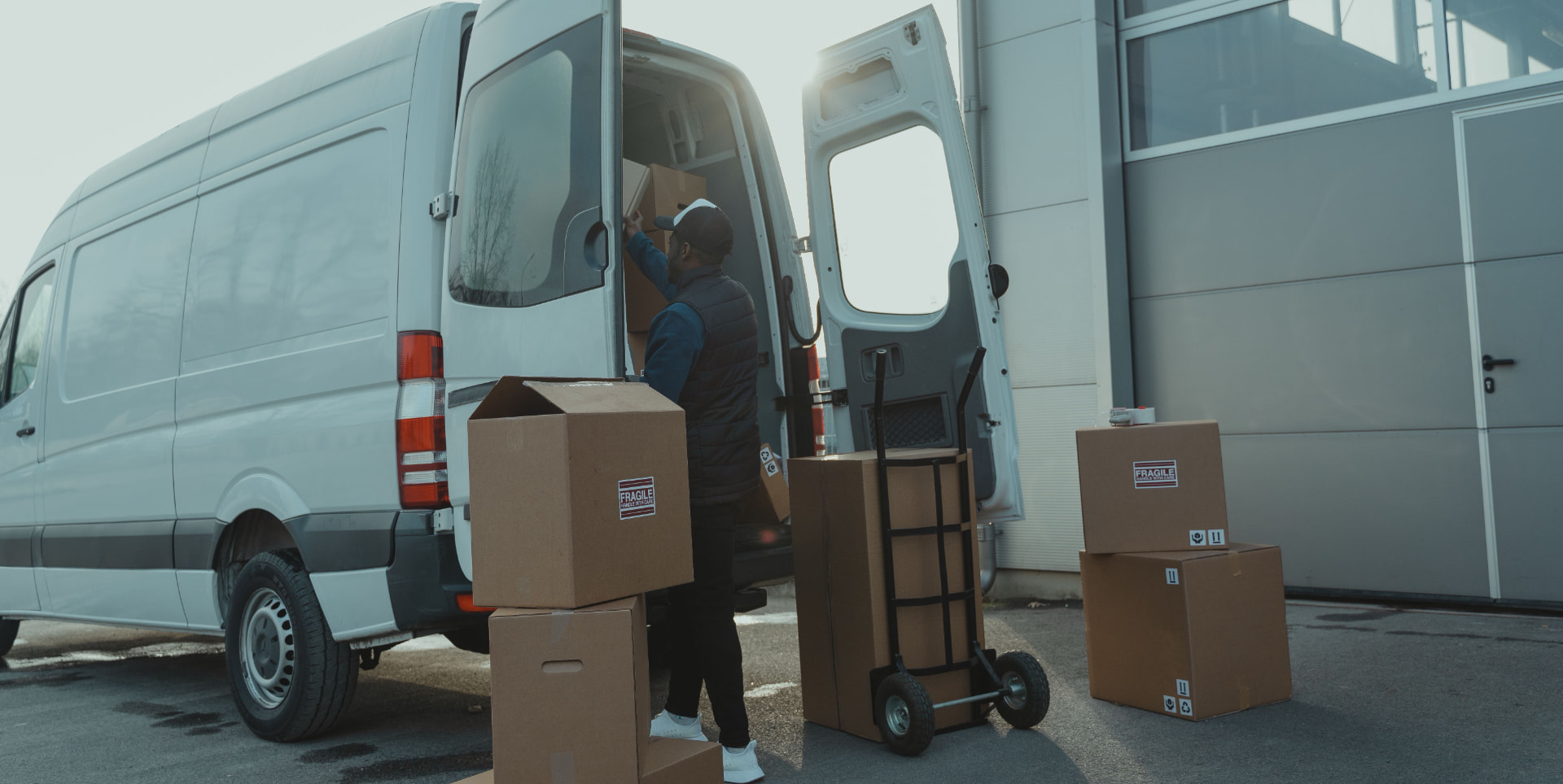 Professional mover loading boxes into a white moving van