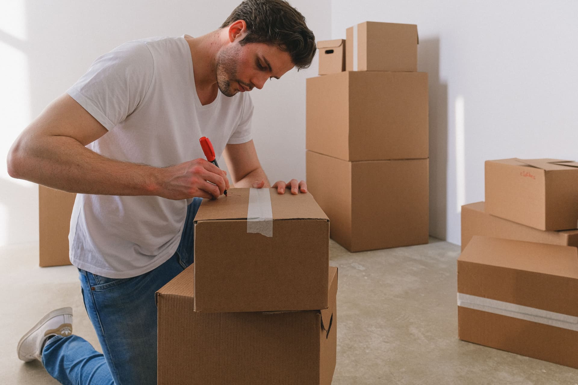 Professional packer sealing moving boxes for transport