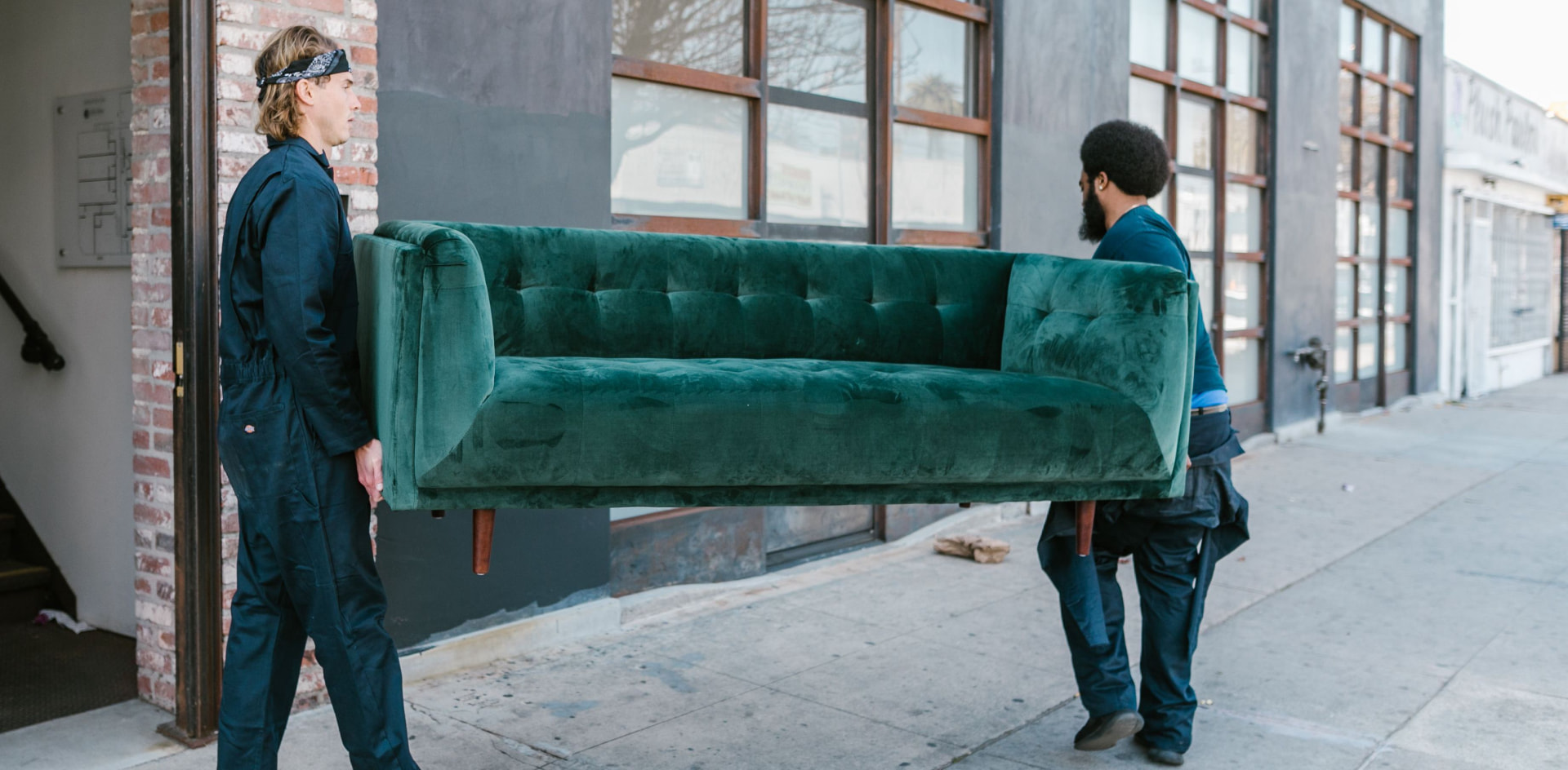 Two professional movers carrying a sofa into a Chicago building