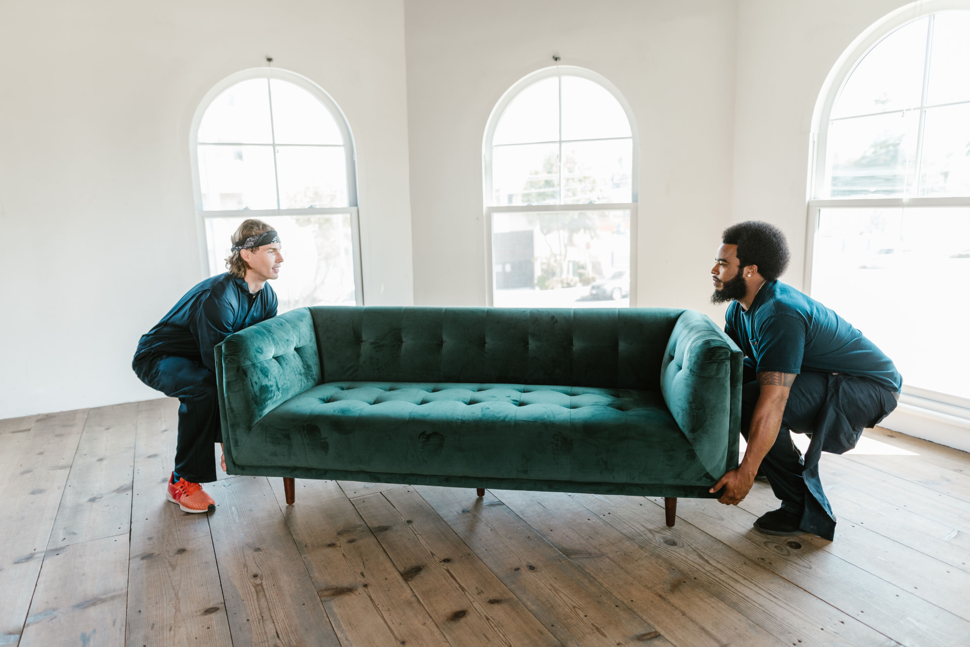 Movers carrying a protected sofa during a residential move