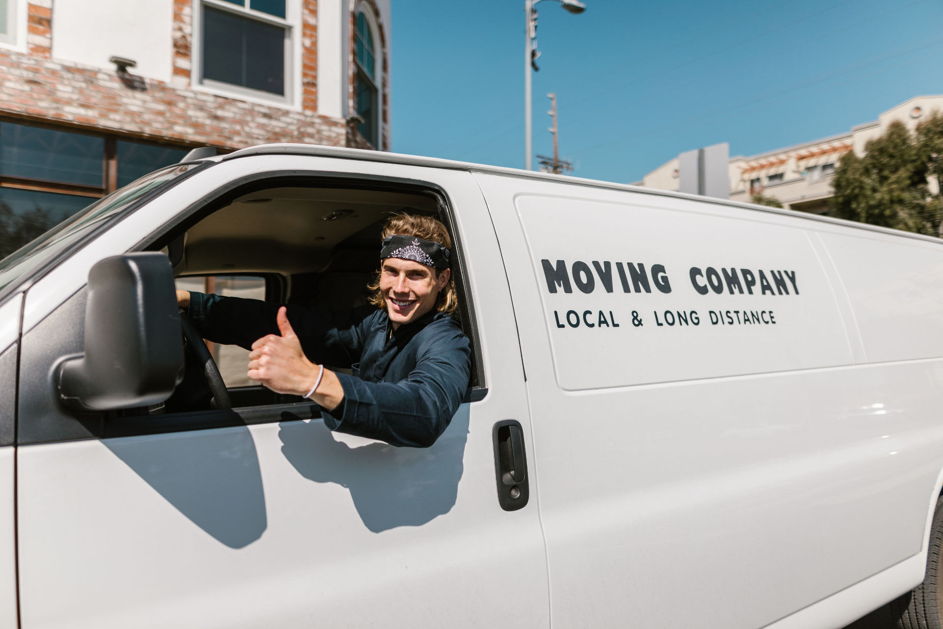 Movers securing wrapped furniture for long-distance transport